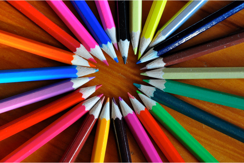 un cercle de crayons de couleur sur une surface en bois pointant l'un vers l'autre