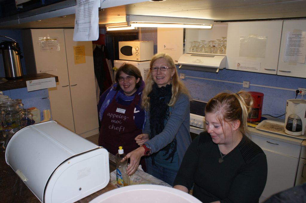 Trois femmes souriantes debout dans une petite cuisine