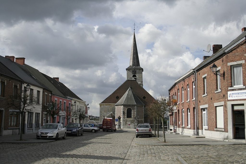 Photo de la place Albert 1er à Froidchapelle, avec l'abside de l'église Sainte-Aldegonde (XVI-XVIIIe siècles).