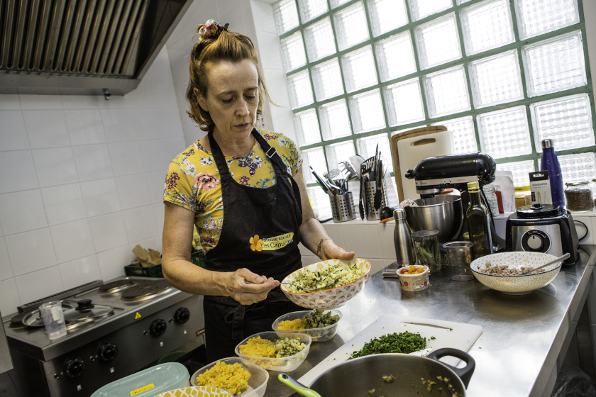 Une femme dans une cuisine professionnel en train de préparer des assiettes
