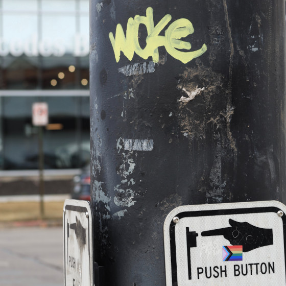 Un tag sur un poteau de rue : WOKE