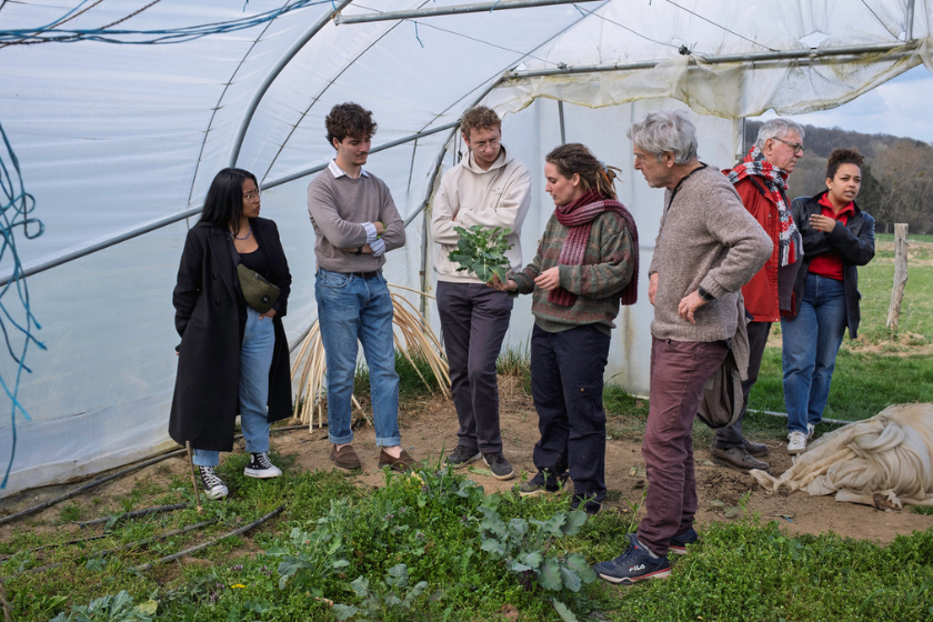 Un groupe de personne autours d'une femme montrant ce qu'est le maraichage